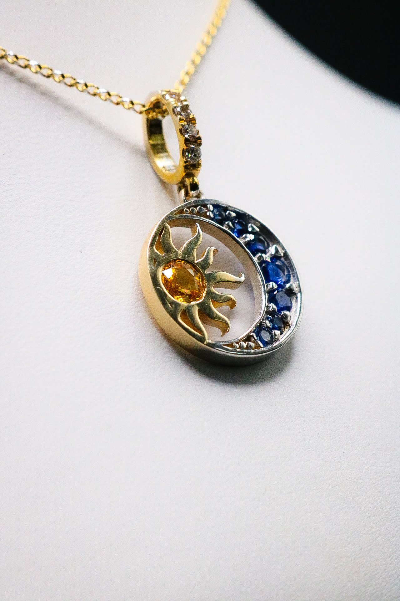 Detail of sun and moon pendant with yellow and blue sapphires